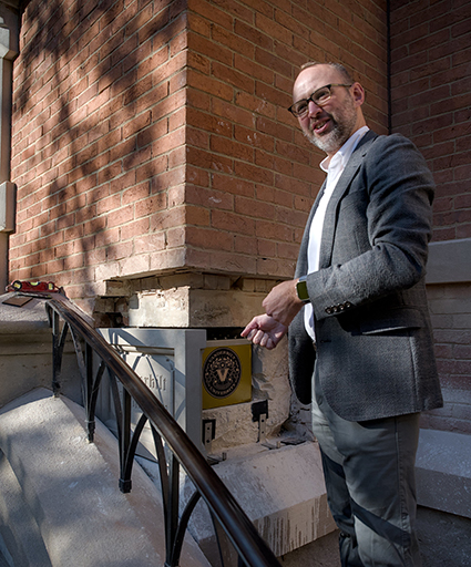 University Librarian Jon Shaw helps place the time capsule in the Kirkland Hall cornerstone. (Tim Gollins/Vanderbilt)