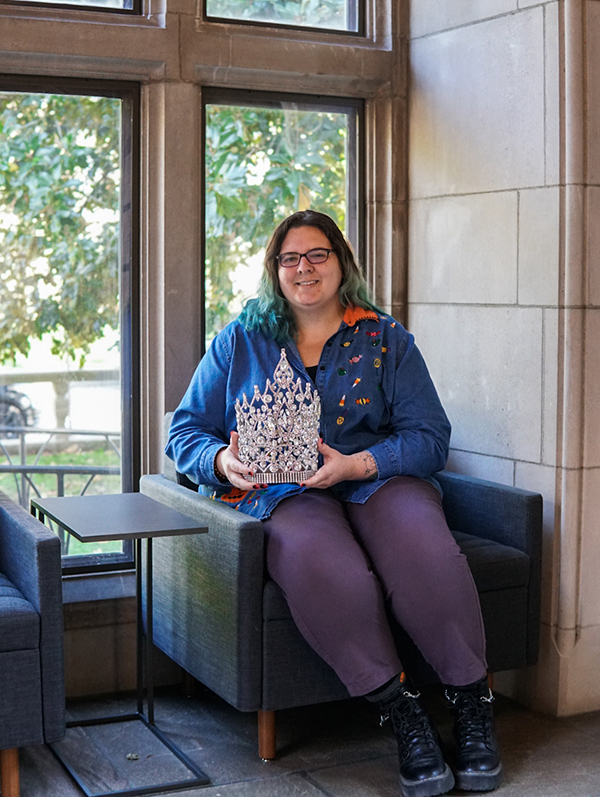 Curator of Community Histories Sarah Calise, with a crown won by Nashville drag performer Carmella Marcella Garcia in 1989 as the inaugural Miss Gay USofA At Large. The item is part of the Ron Sanford Papers collection. (Nikita Rohila/Vanderbilt)