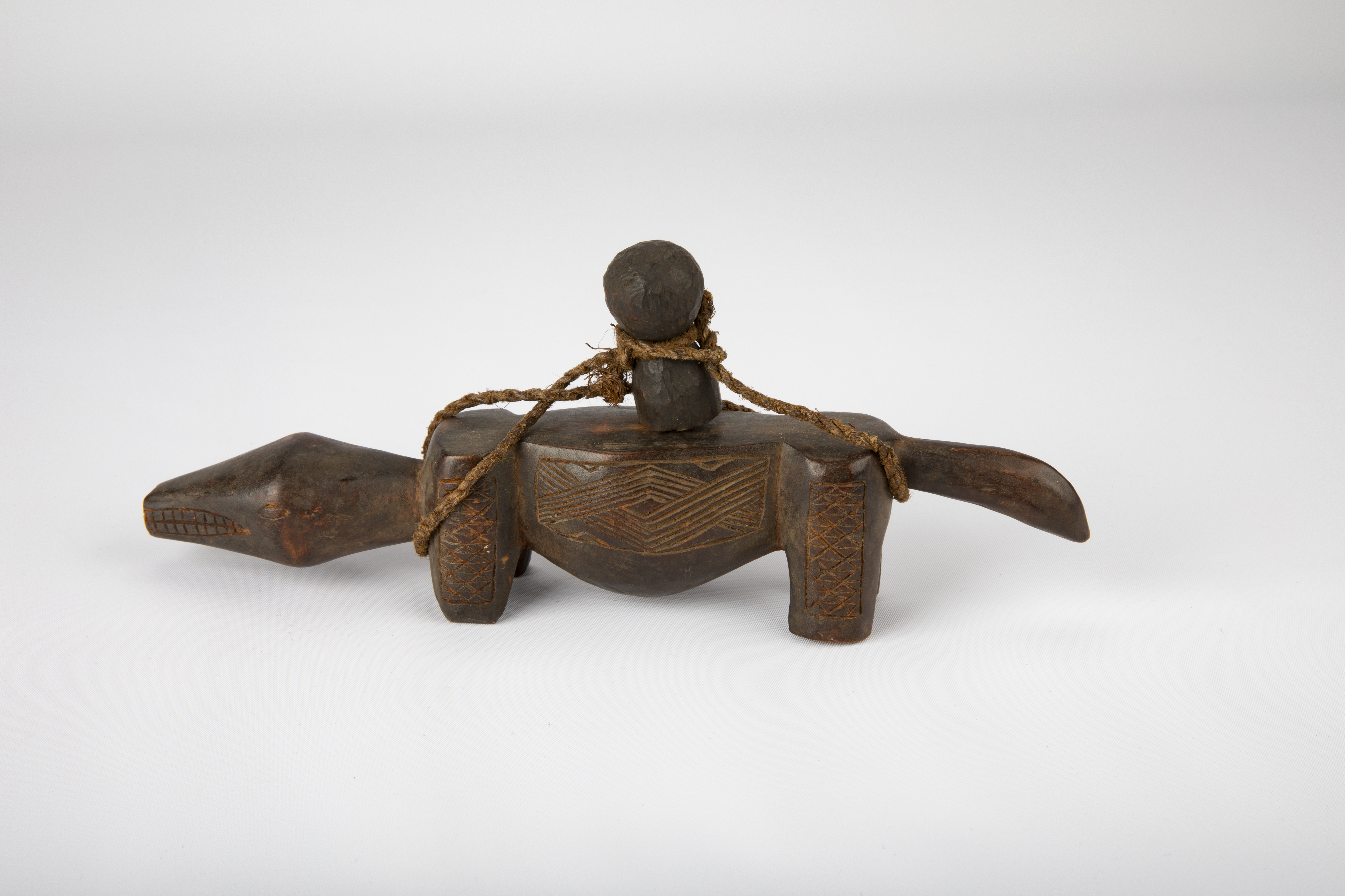 Divination instrument in the shape of an animal with long  protruding head and tail with small rubbing staff attached, Africa (Zaire, Babuba or Lele), 19th century